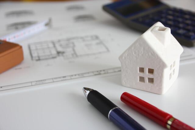 住宅設計図と電卓が置かれた机