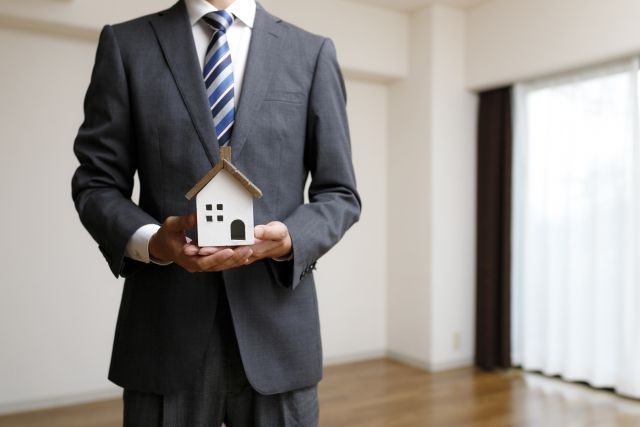 デザイン住宅の模型を持つビジネスマン